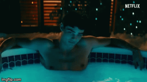 A Shirtless Man Is Laying In A Hot Tub With A Netflix Logo Behind Him GIF