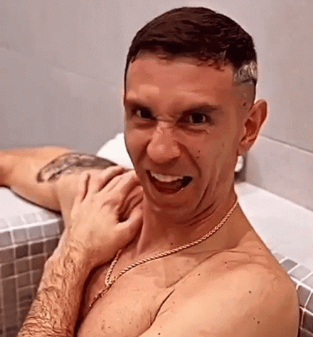 A Shirtless Man Is Making A Funny Face While Taking A Bath . GIF