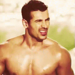 A Shirtless Man Is Making A Funny Face With His Tongue Sticking Out . GIF