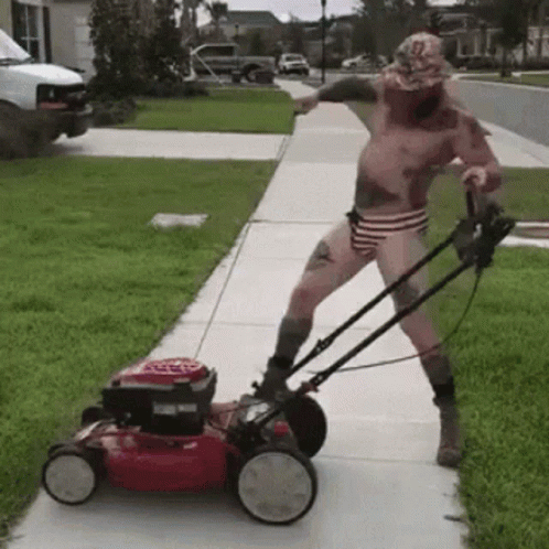 A Shirtless Man Is Pushing A Lawn Mower Down The Sidewalk GIF