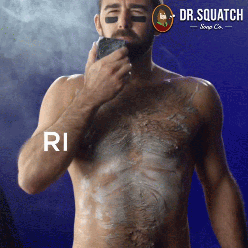 A Shirtless Man Is Shaving His Chest With A Dr. Squatch Soap Co. Logo Behind Him GIF