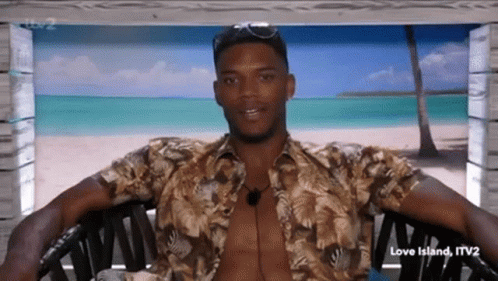 A Shirtless Man Is Sitting In A Chair With His Arms Outstretched . GIF