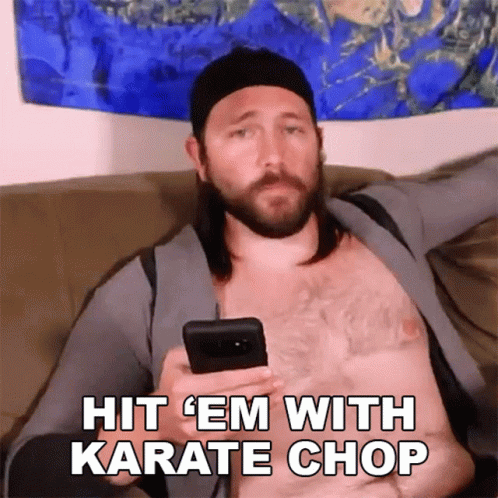 A Shirtless Man Is Sitting On A Couch Holding A Cell Phone With The Words Hit Em With Karate Chop Below Him GIF