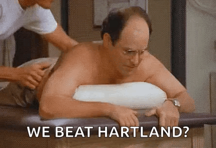 a shirtless man is sitting on a table getting a massage from a nurse .