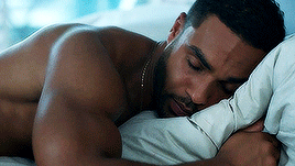 A Shirtless Man Is Sleeping On A Bed With A Pillow . GIF