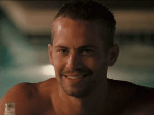 A Shirtless Man Is Smiling And Holding A Bottle Of Beer GIF