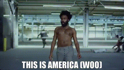 A Shirtless Man Is Standing In A Room With The Words `` This Is America ( Woo ) '' Written On The Screen . GIF