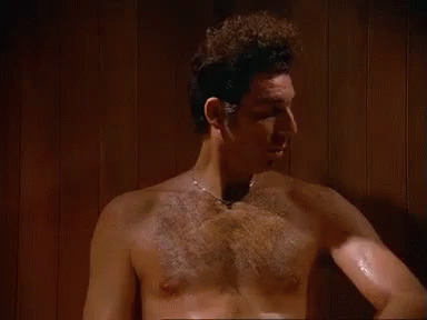 A Shirtless Man Is Standing In A Sauna With The Words `` It 'S Like A Sauna In Here '' . GIF