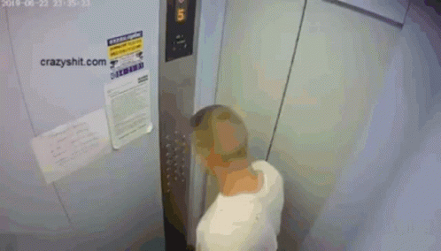 A Shirtless Man Is Standing In An Elevator With A Sign That Says Crazyshit.com On It GIF