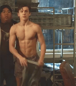 a shirtless man is standing in front of a bunk bed in a bedroom .