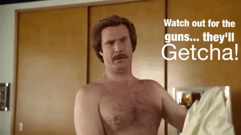 Shirtless Man Standing In Front Of Watch Out For Guns Sign GIF