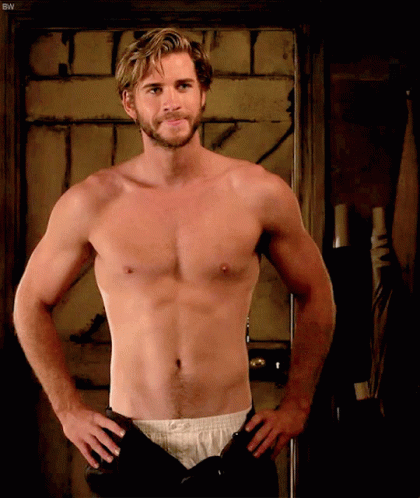 A Shirtless Man Is Standing With His Hands On His Hips In Front Of A Door With The Letters Bw On It GIF