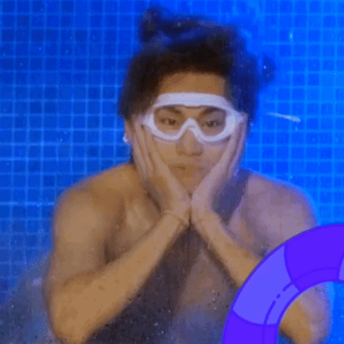 A Shirtless Man Is Swimming In A Pool Wearing Goggles . GIF