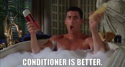 A Shirtless Man Is Taking A Bath In A Bathtub While Holding A Conditioner And A Sponge . GIF
