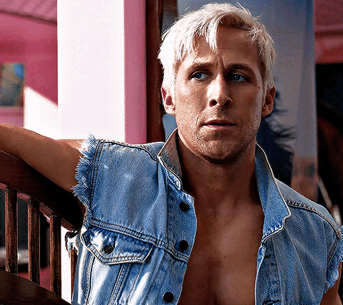A Shirtless Man Leaning Against A Railing Wearing A Blue Denim Vest GIF