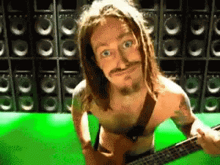 A Shirtless Man Playing A Guitar In Front Of Speakers GIF