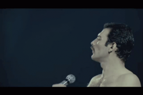 A Shirtless Man Singing Into A Microphone With The Word Pressure Written Below Him GIF