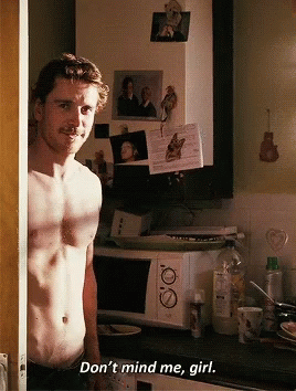 A Shirtless Man Standing In A Kitchen With The Words " Don 'T Mind Me Girl " Written On The Bottom GIF