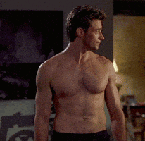 A Shirtless Man Standing In A Living Room GIF