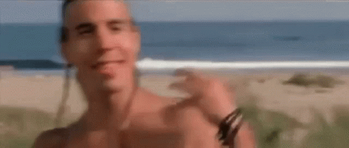 A Shirtless Man Standing On A Beach With The Words That Would Above Him GIF