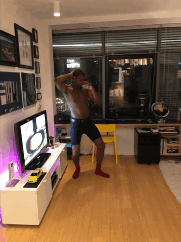 A Shirtless Man Stands In Front Of A Samsung Flat Screen Tv GIF