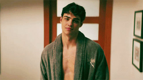 A Shirtless Man Wearing A Grey Robe With A Puma Logo On His Chest GIF