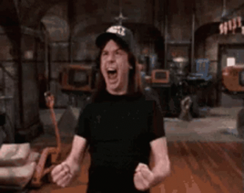 A Shirtless Man Wearing A Hat Is Screaming In A Dark Room . GIF