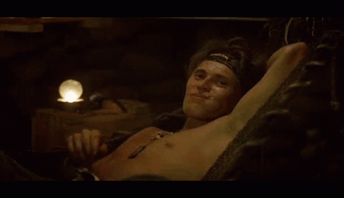A Shirtless Man Wearing A Headband With The Word Warrior On It Waves His Hand GIF
