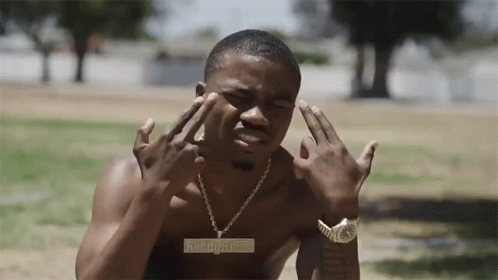 A Shirtless Man Wearing A Watch And A Necklace With A Pendant That Says ' Aboogy.com ' GIF
