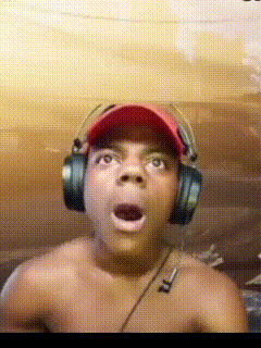 A Shirtless Man Wearing Headphones And A Baseball Cap Looks Surprised GIF