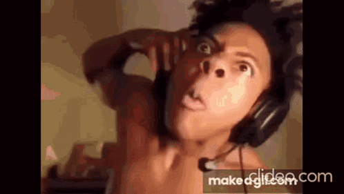 A Shirtless Man Wearing Headphones And A Microphone . GIF