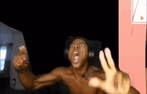 A Shirtless Man Wearing Headphones Is Making A Funny Face While Sitting In A Chair . GIF