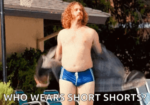 A Shirtless Man Wearing Short Shorts Is Standing Next To A Pool With The Words Who Wears Short Shorts . GIF
