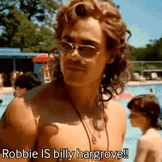 A Shirtless Man Wearing Sunglasses And A Necklace Is Standing Next To A Pool . GIF
