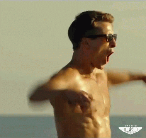 A Shirtless Man Wearing Sunglasses Is Screaming On The Beach . GIF