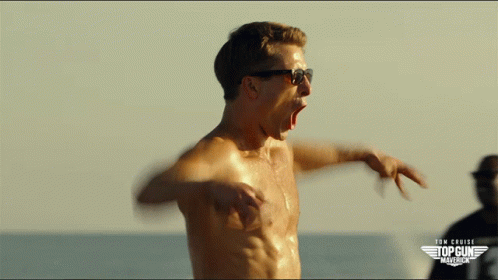 A Shirtless Man Wearing Sunglasses Stands In Front Of A Sign That Says Tom Cruise Top Gun America GIF
