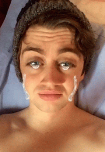 A Shirtless Man With A Beanie On Has A Tear Coming Out Of His Eye GIF