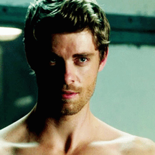 A Shirtless Man With A Beard And A Shadow On His Face GIF