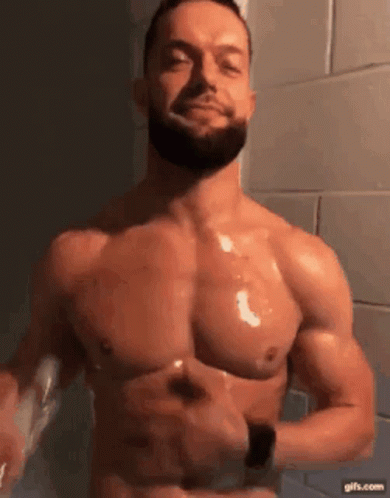 A Shirtless Man With A Beard Is Brushing His Teeth With A Toothbrush In A Bathroom . GIF