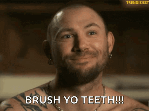 A Shirtless Man With A Beard Is Smiling And Says Brush Yo Teeth GIF