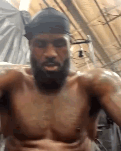 A Shirtless Man With A Beard Is Taking A Selfie GIF