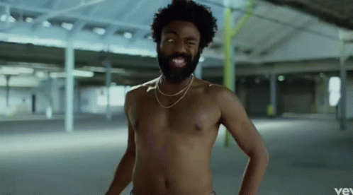 A Shirtless Man With A Beard Is Wearing A Gold Chain Around His Neck And Smiling . GIF