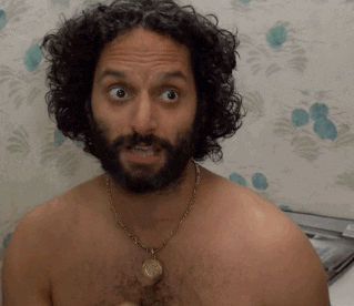 A Shirtless Man With A Beard Wearing A Necklace GIF