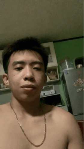 A Shirtless Man With A Chain Around His Neck Is Taking A Selfie GIF