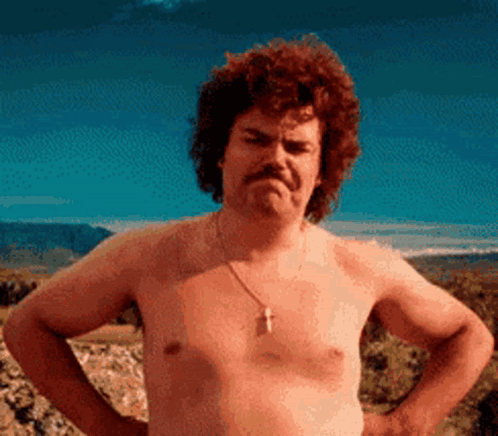 A Shirtless Man With A Moustache Is Standing With His Hands On His Hips . GIF