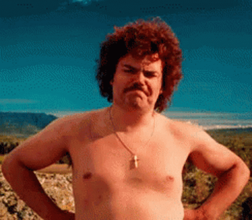 A Shirtless Man With A Mustache And A Cross Necklace Stands With His Hands On His Hips GIF