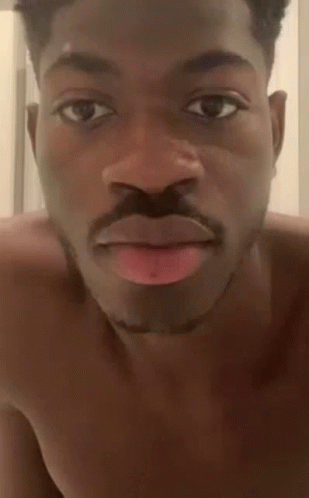 A Shirtless Man With A Mustache Is Making A Funny Face With His Tongue Sticking Out . GIF