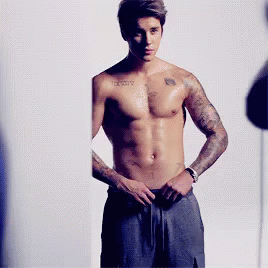 A Shirtless Man With A Tattoo On His Chest That Says ' Infinity ' GIF