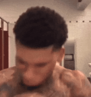 A Shirtless Man With A Tattoo On His Shoulder Is Looking Down GIF