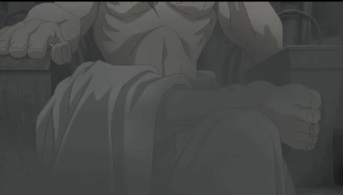 A Shirtless Man With Long Blonde Hair Is Sitting In A Chair GIF